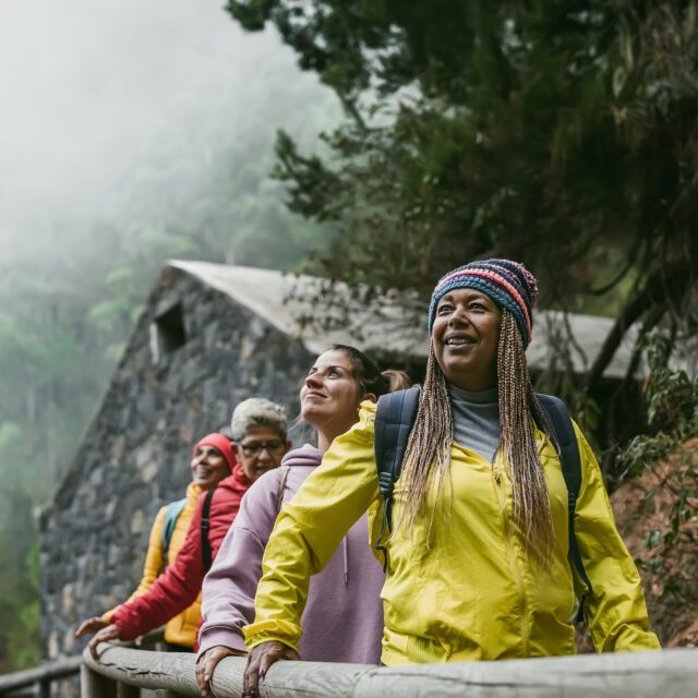 Group of women with different ages and ethnicities having fun wa Group of women with different ages and ethnicities having fun walking in foggy forest - Adventure and travel people concept